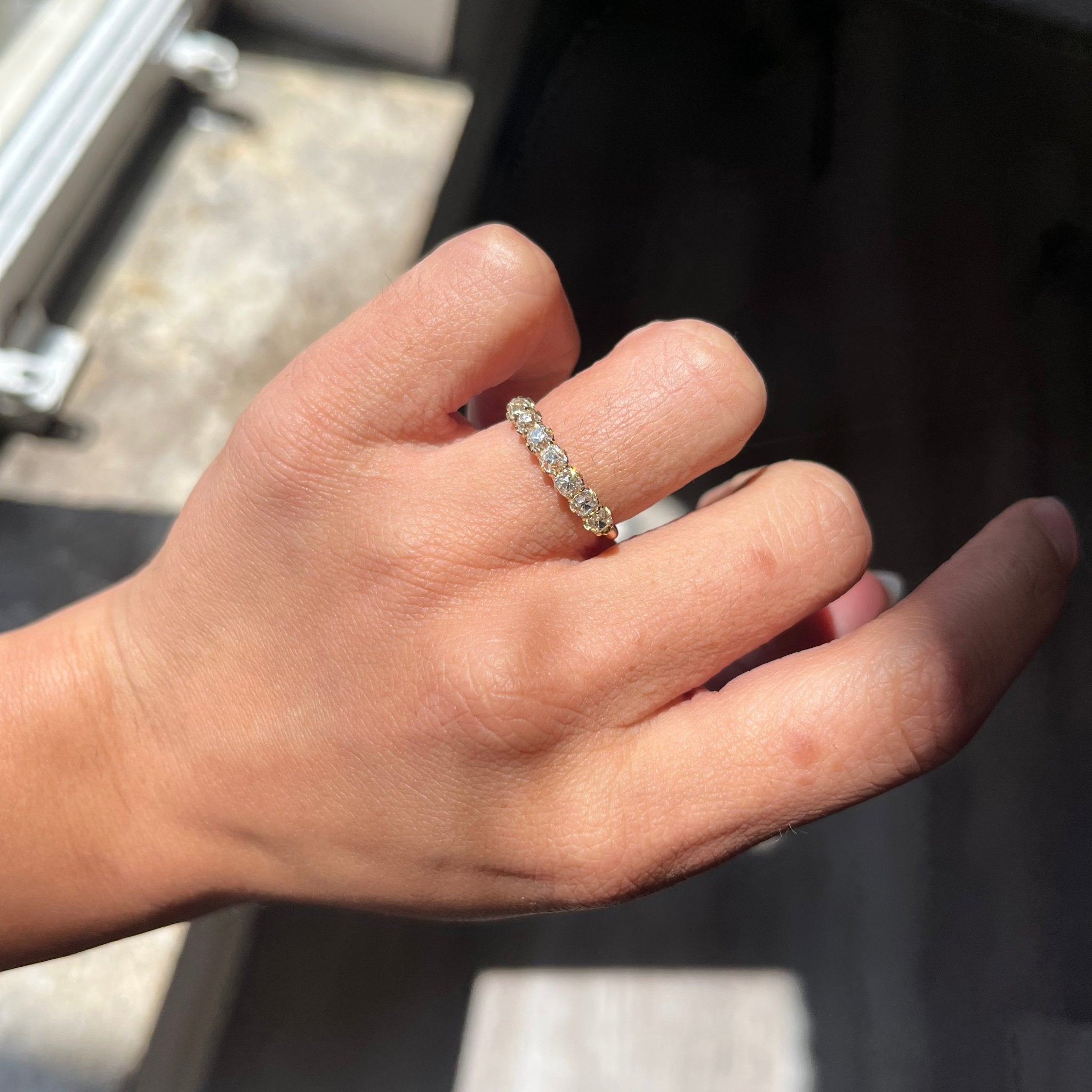 Elegant 1.03ctw Petite Old Mine Cut Diamond 7-Stone Half-Hoop Band, romantic design with Old Mine Cut Diamonds, Earth-mined diamonds in yellow gold shown on ring finger