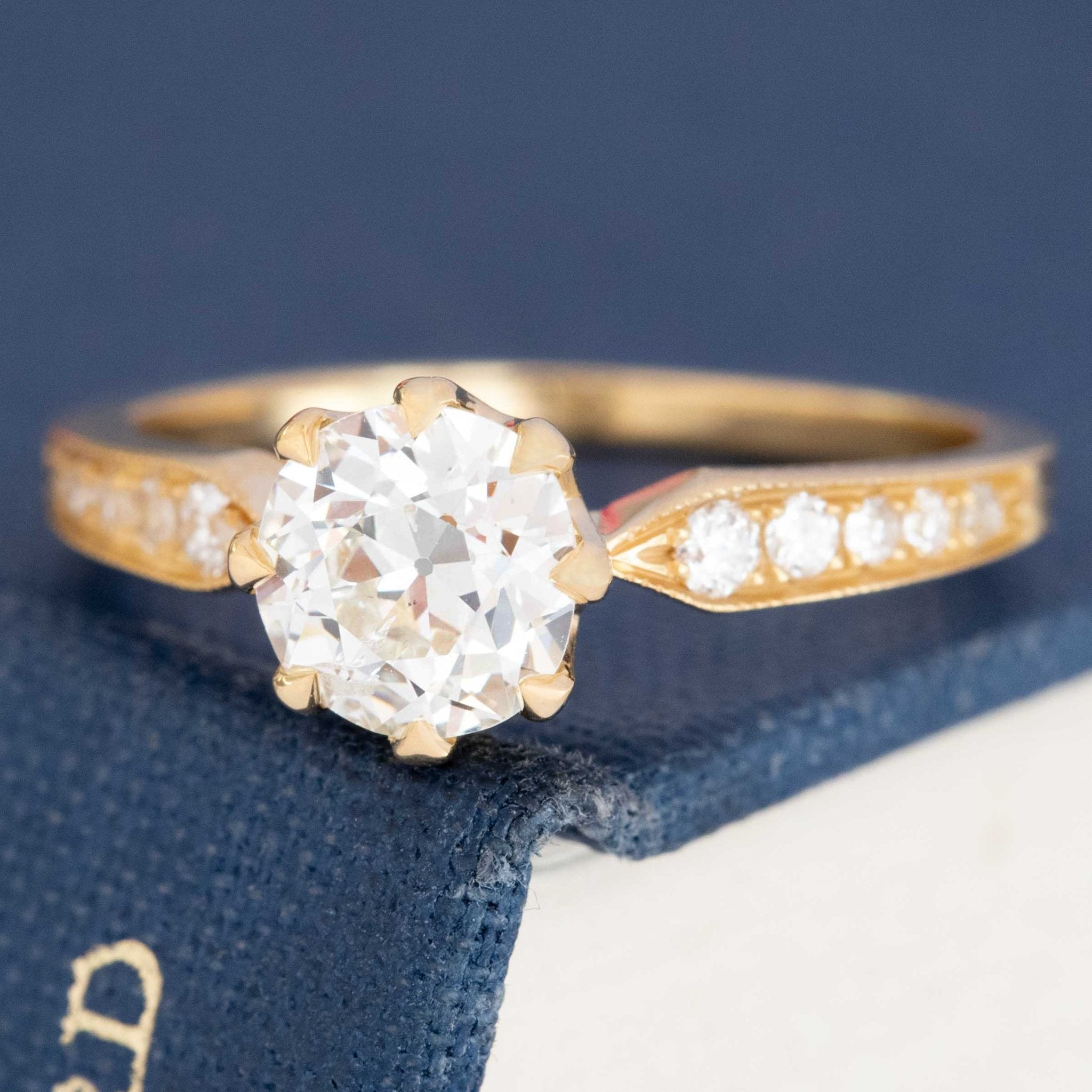 Classic diamond engagement ring with OEC center and side stones, vintage 18k gold setting.