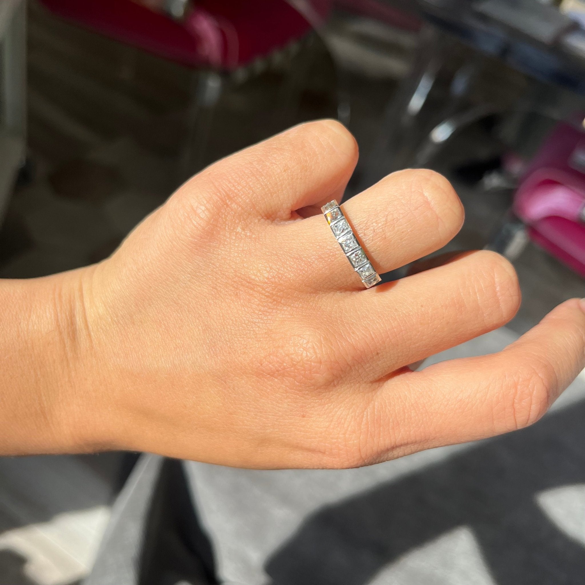 Elegant 1.06ctw French Cut Diamond 7-Stone Bezel Band, romantic design with French Cut Diamonds, Earth-mined diamonds in platinum shown on ring finger