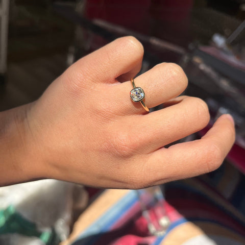 Vintage old mine cut diamond set in bezel solitaire yellow gold ring close-up