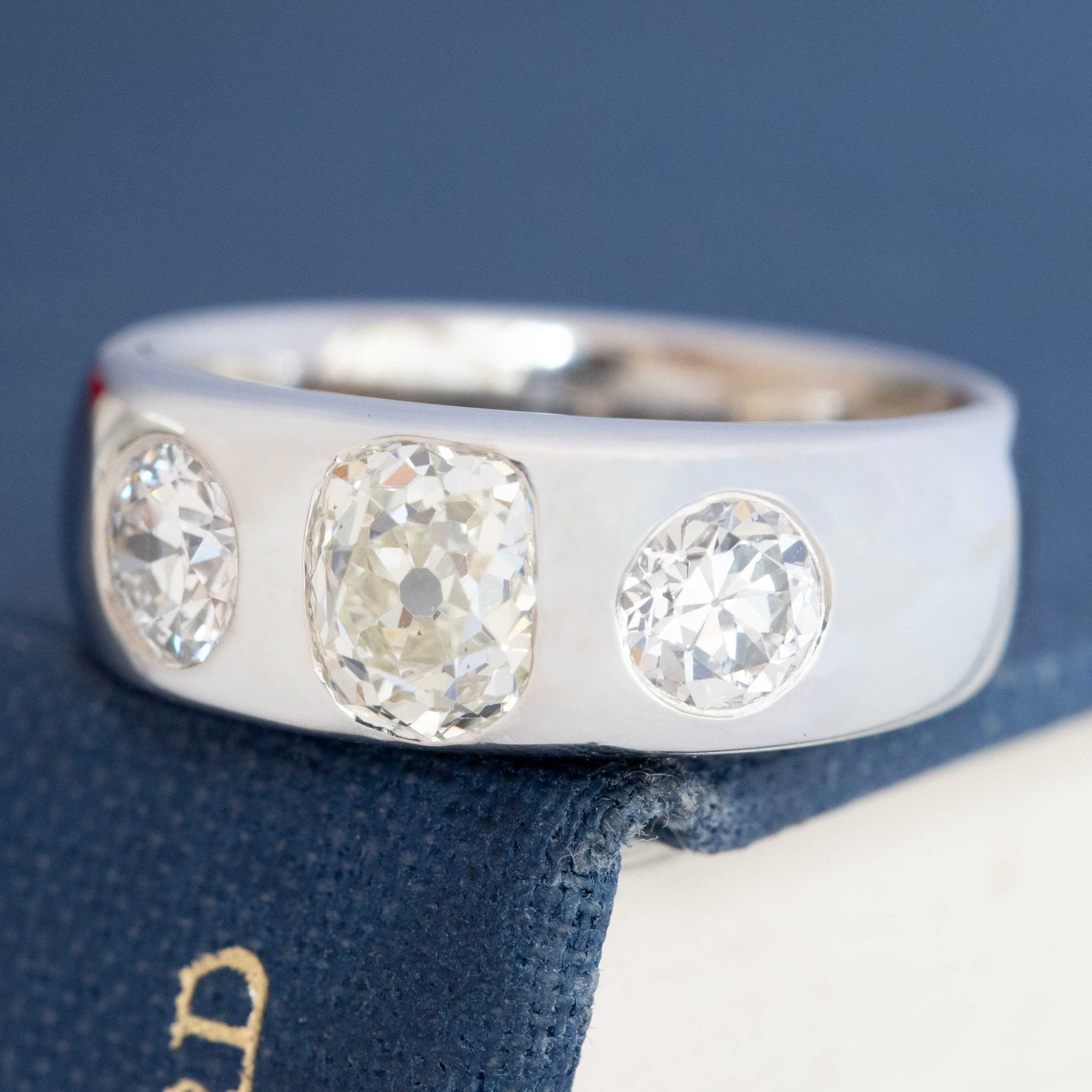 Old cut diamond three-stone ring, center stone flanked by antique cuts