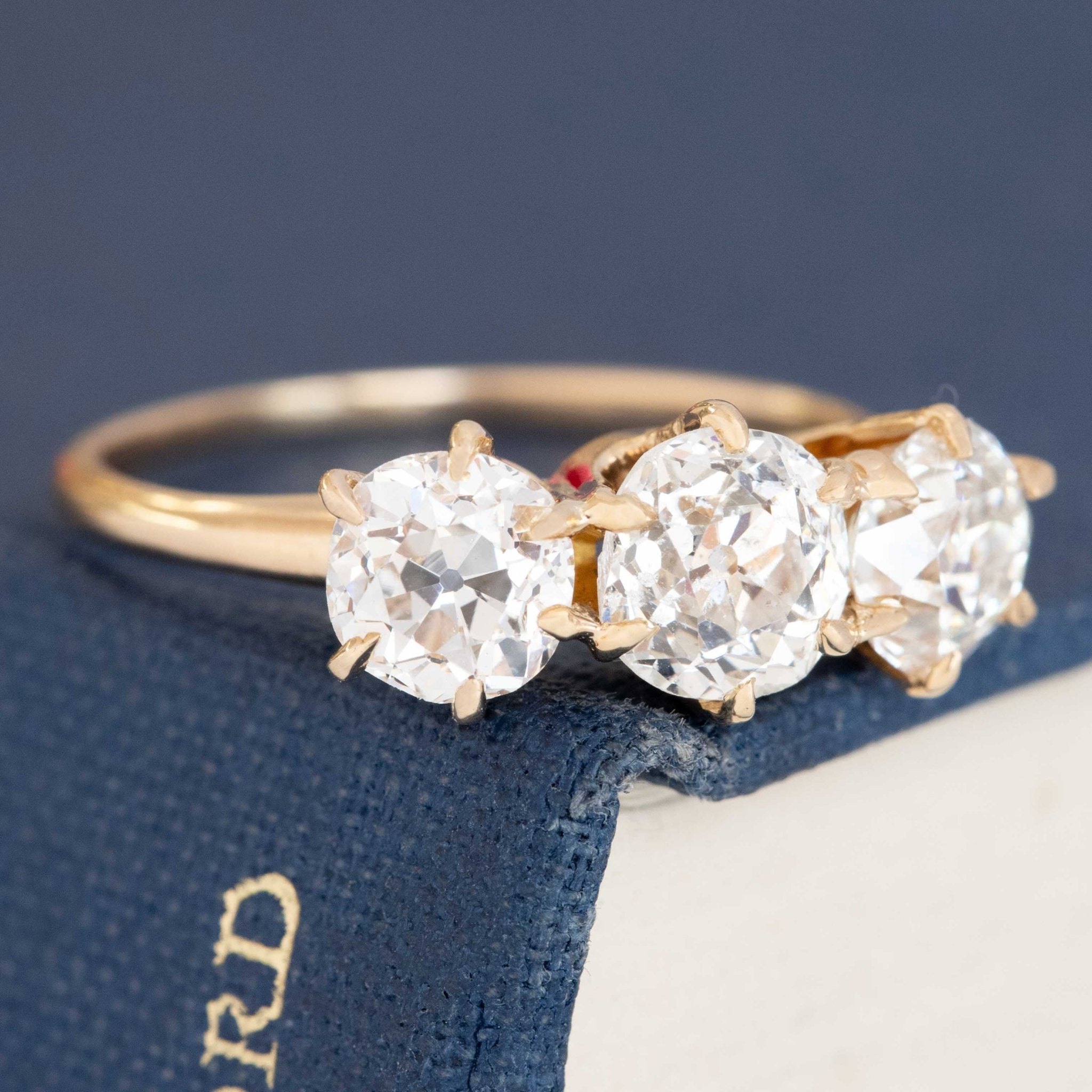 A antique 3-stone ring set with chunky old mine cut diamonds in a rosy yellow gold. Perfect vintage engagement ring choice