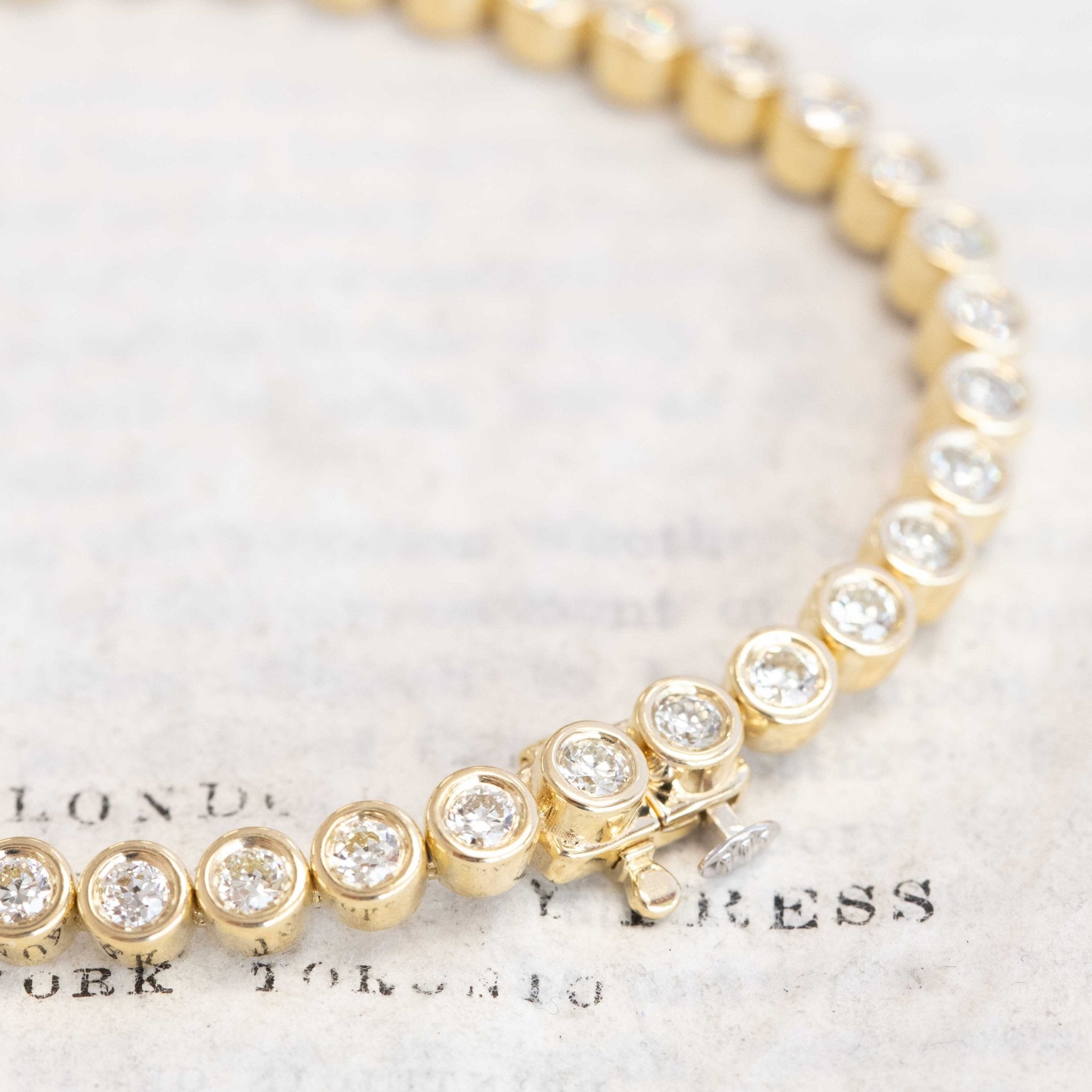 Close-up of bezel-set Old European cut diamonds in yellow gold tennis bracelet