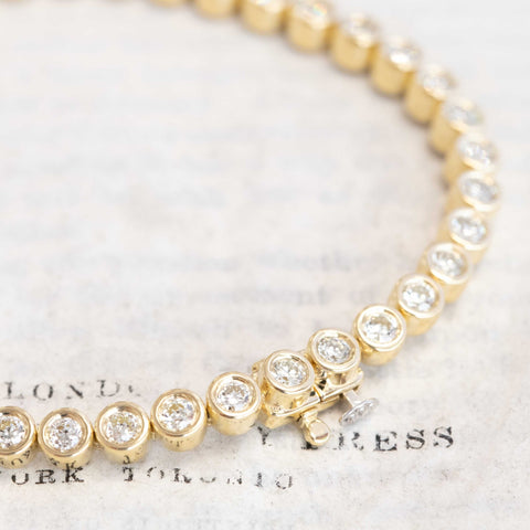 Close-up of bezel-set Old European cut diamonds in yellow gold tennis bracelet