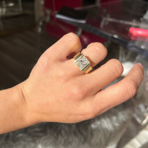 Retro 1970s princess cut diamond solitaire with chunky gold setting shown on ring finger