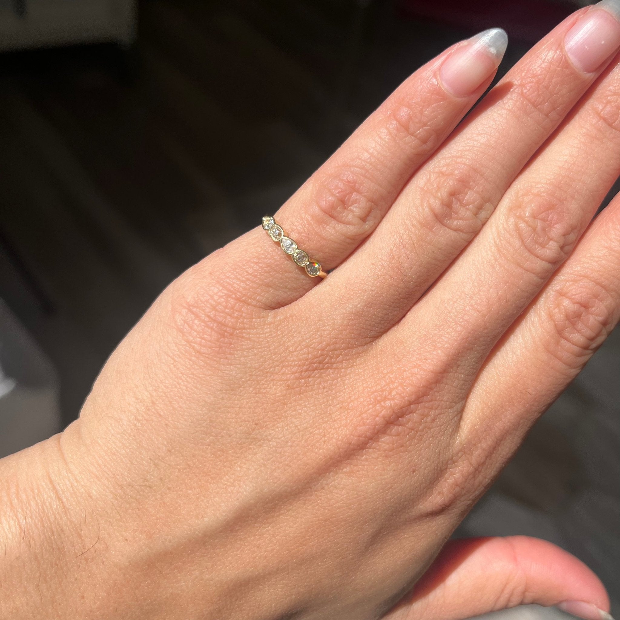 Elegant .41ctw Petite Mixed Cut Diamond Bezel Band, romantic design with Old Mine Cut Diamonds, Earth-mined diamonds in yellow gold shown on ring finger.