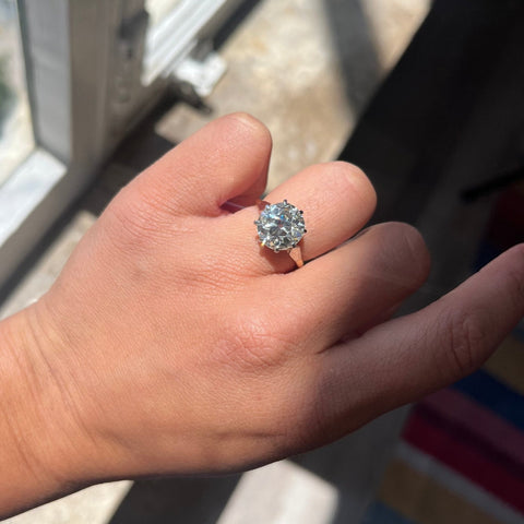 Transitional-era Old Mine Cut diamond with chunky facets and elongated shape on model.