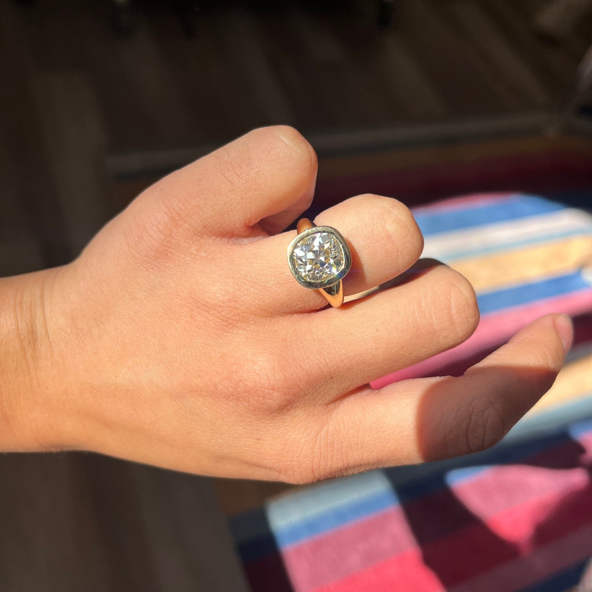 Top view antique style old mine cut diamond ring, solid gold bezel setting, worn on a hand
