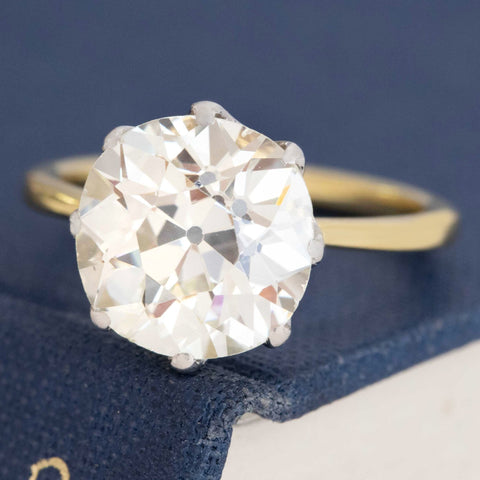 Platinum and yellow gold antique diamond solitaire with timeless design.