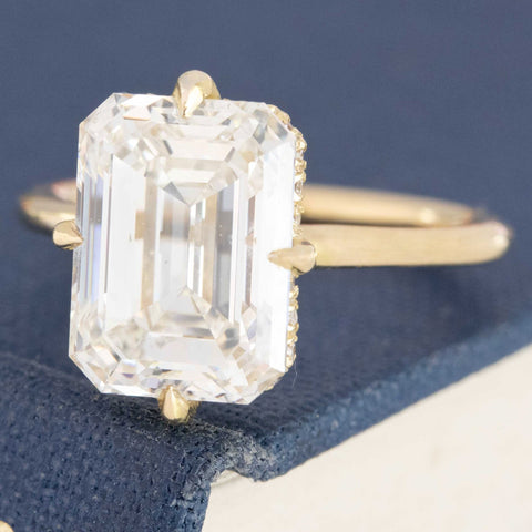 Modern classic emerald cut diamond ring, hidden halo design.