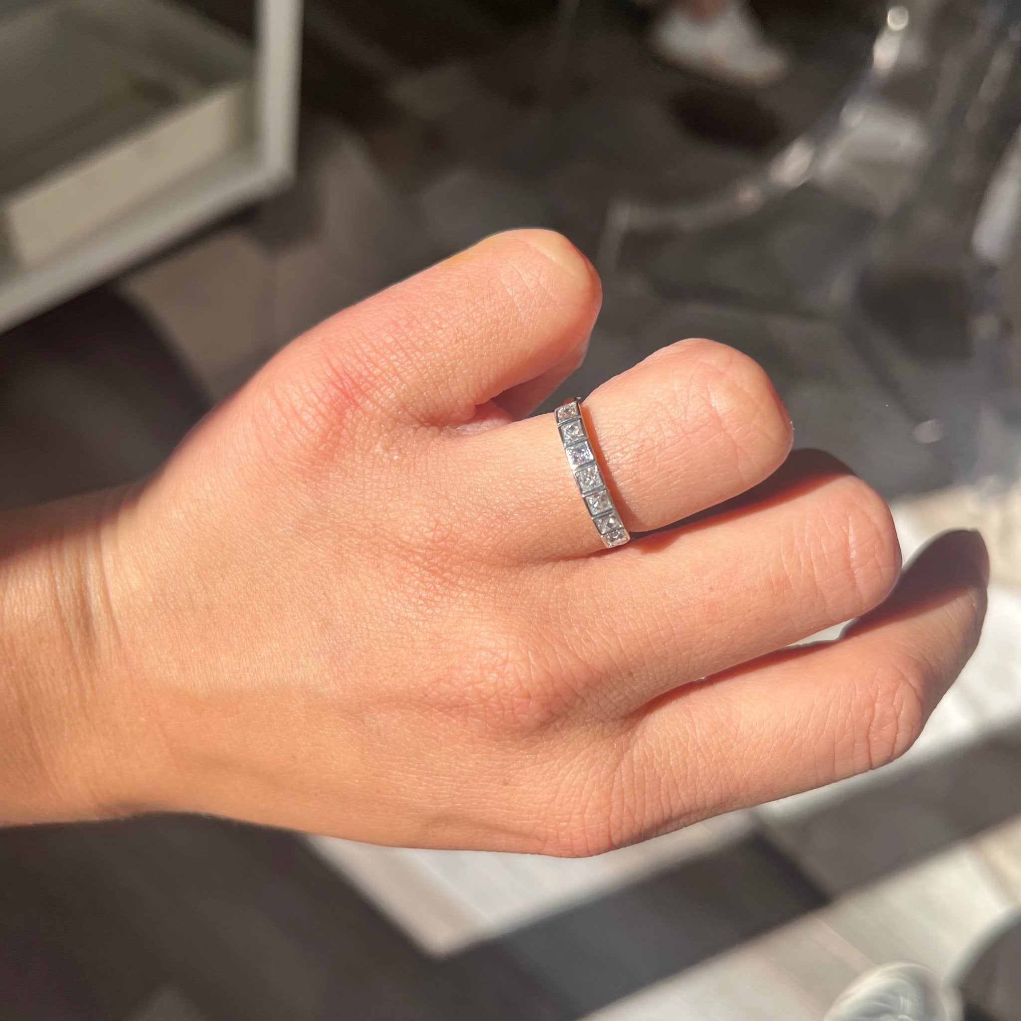 Elegant .58ctw French Cut Diamond Half-Hoop Bezel Band, romantic design with French Cut Diamonds, Earth-mined diamonds in platinum shown on ring finger.