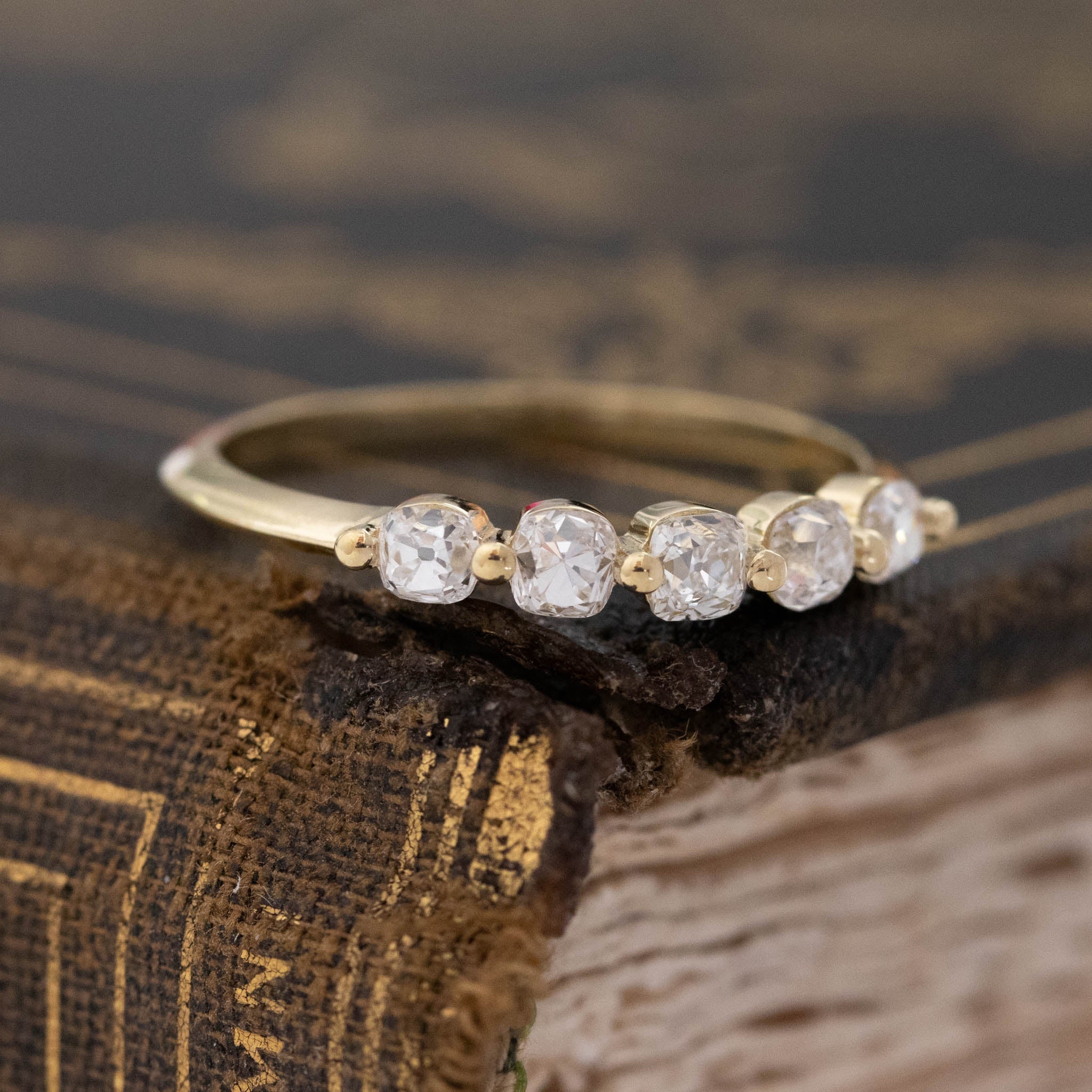 Close-up of .58ctw Petite Old Mine Cut Diamond Shared Prong Band, vintage-inspired band with Old Mine Cut Diamonds, crafted in yellow gold.