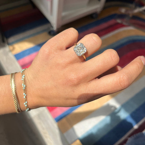 Elegant Asscher cut collet solitaire, timeless engagement ring shown on finger
