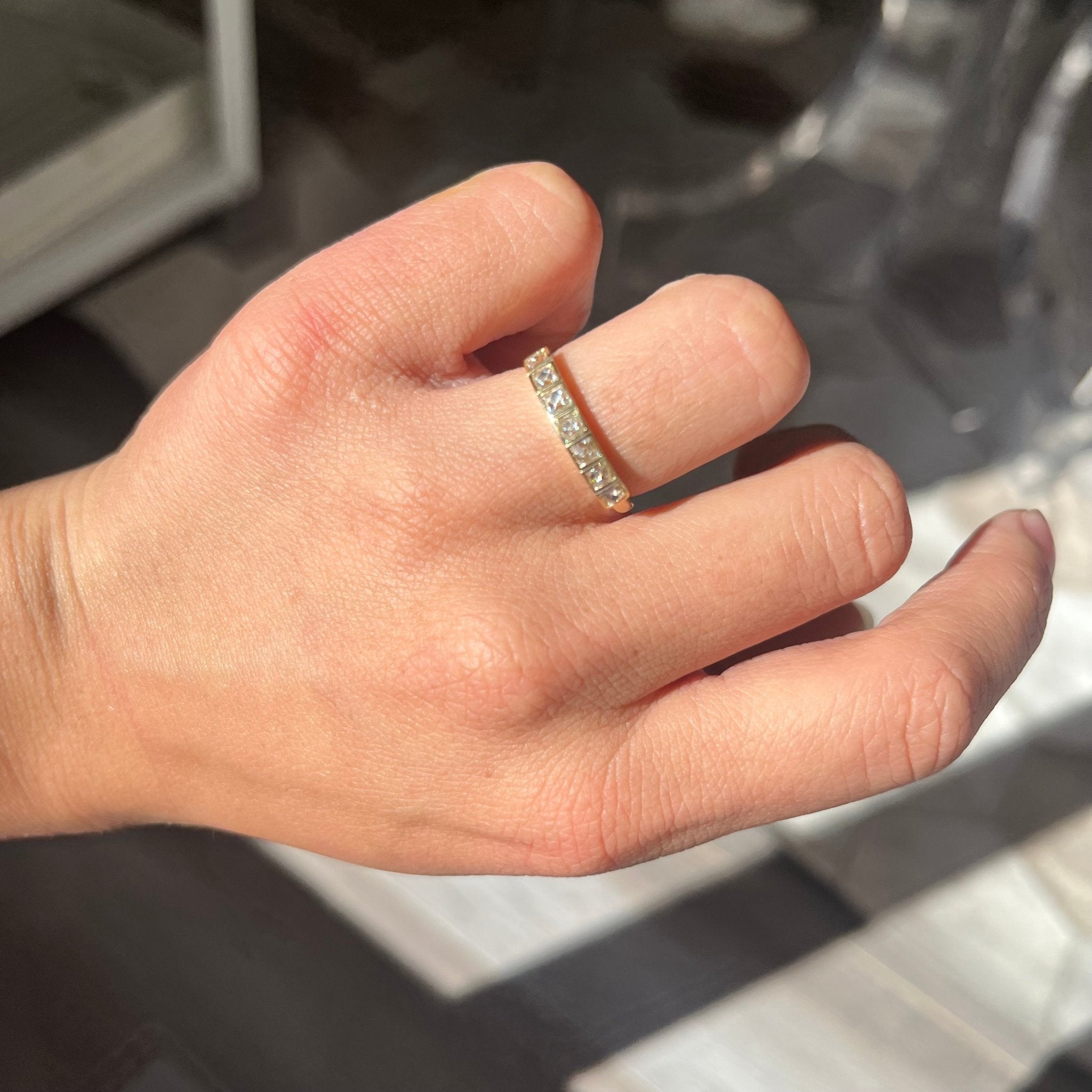 Elegant .65ctw French Cut Diamond Half-Hoop Bezel Band, romantic design with French Cut Diamonds, Earth-mined diamonds in yellow gold shown on ring finger