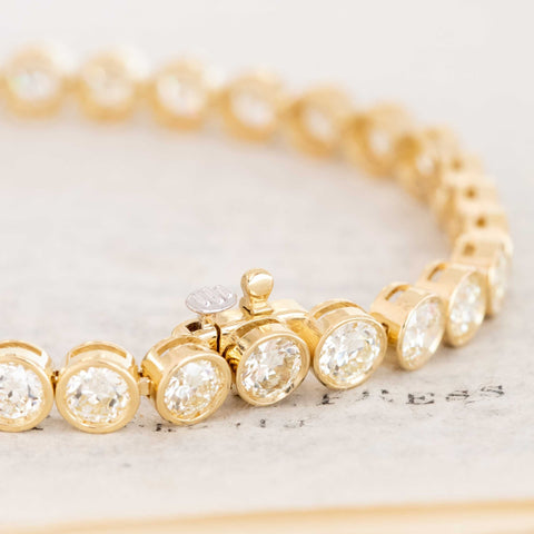 Close-up of recycled Old European cut diamonds bezel-set in yellow gold. Detail of 18kt yellow gold bezels highlighting antique diamond faceting