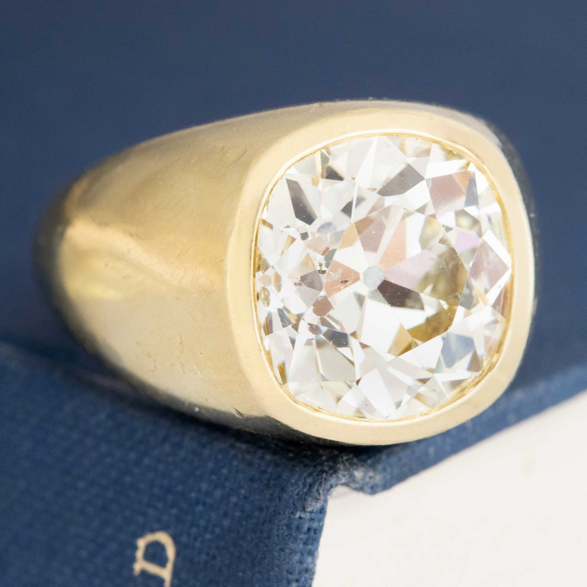 Close-up of vintage engagement ring with 9.33ct old mine cut diamond in bold bezel setting