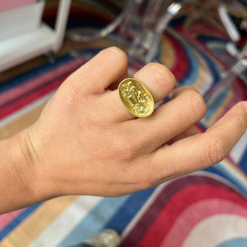 A vintage high karat signet ring by designer Zolotas depicting "Leda and the swan." One of a kind and a rare jewel. Shown on a finger.