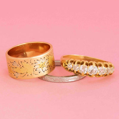 Three antique and vintage bands in gold and platinum on a pink background