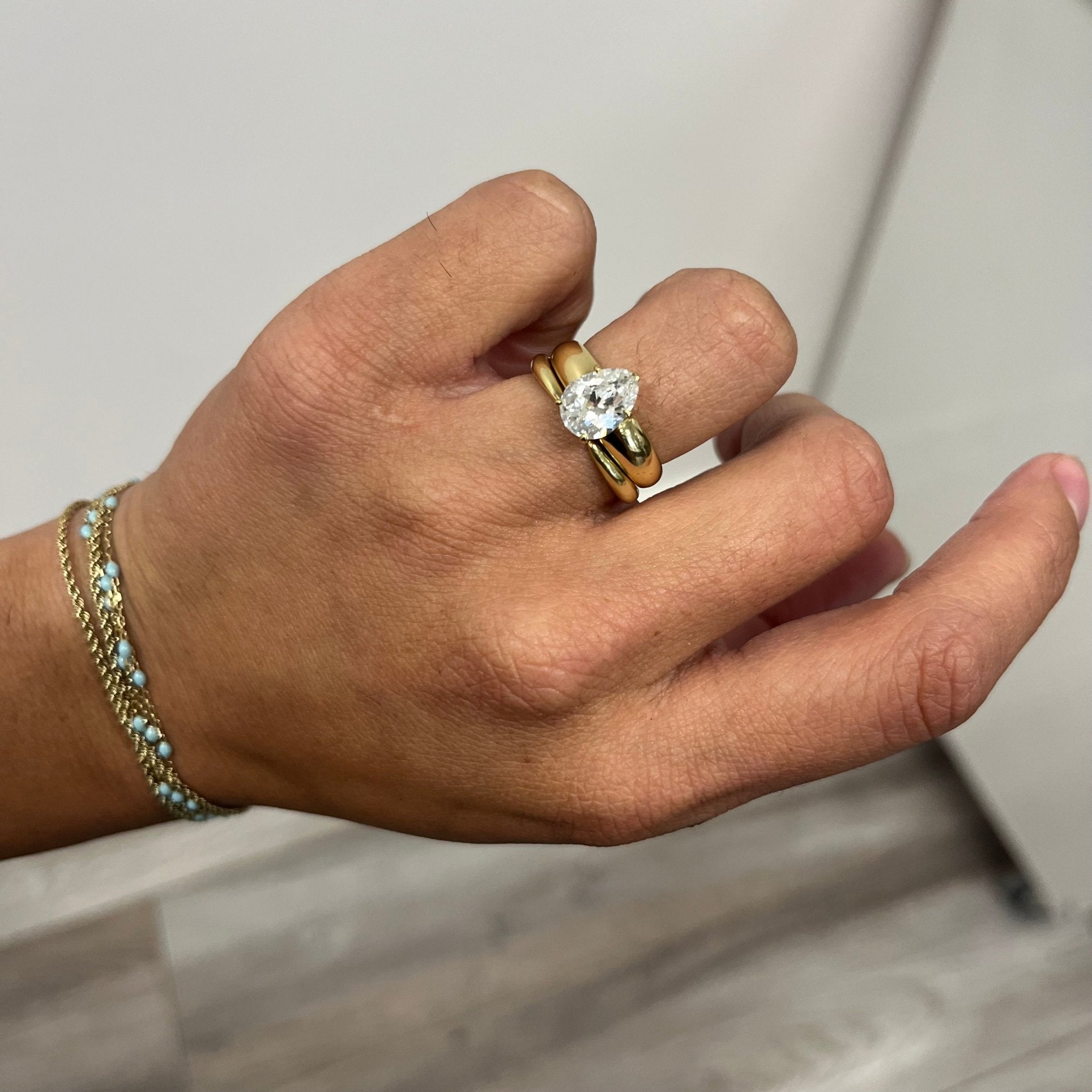 Elegant "Arc" Wedding Band in Yellow Gold, romantic design stacked beneath a diamond solitaire in yellow gold.