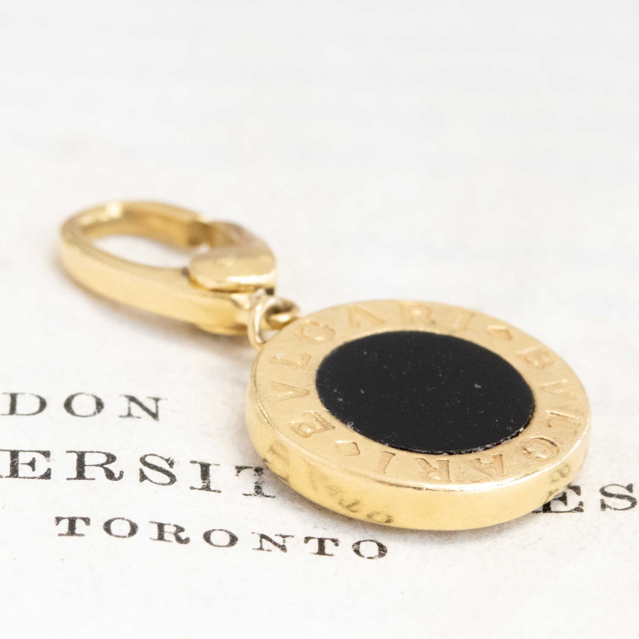 Luxury vintage Bvlgari pendant crafted in 18k yellow gold with pavé-set brilliant white diamonds and bold BVLGARI logo, authentic collectible Italian designer jewelry offered by Jewels by Grace