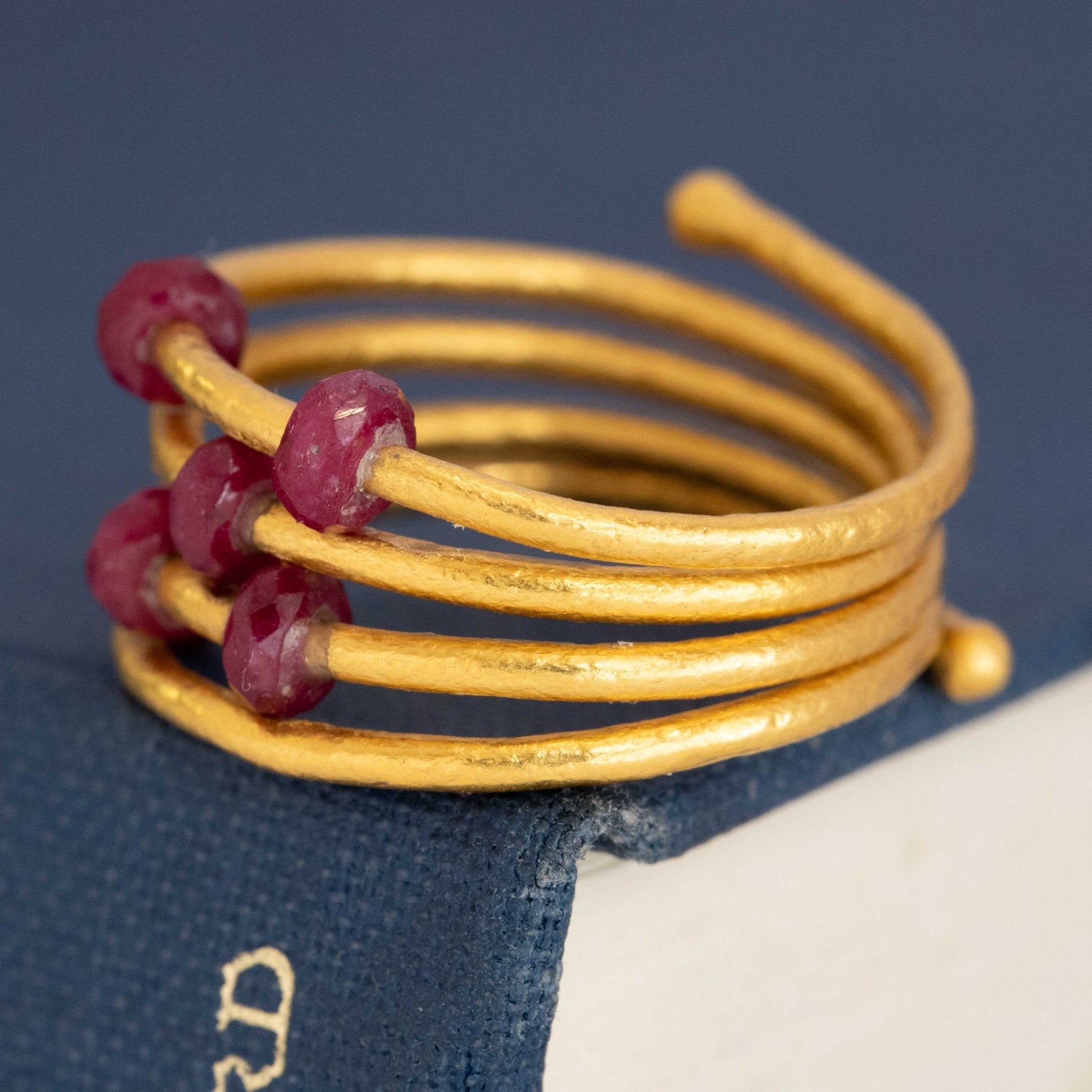 Handmade 24 karat gold ruby ring by Gurhan with bold coil design and vibrant red ruby accents.