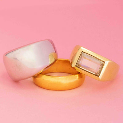 Men’s vintage rings in gold and platinum with bold silhouettes on pink background