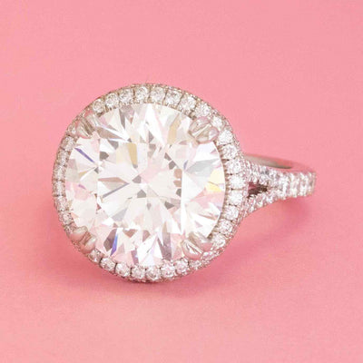 Modern round brilliant diamond engagement ring with halo and pavé band in white gold