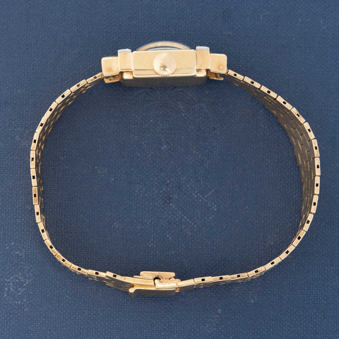 Square-dial Tiffany watch in 14k gold on blue book