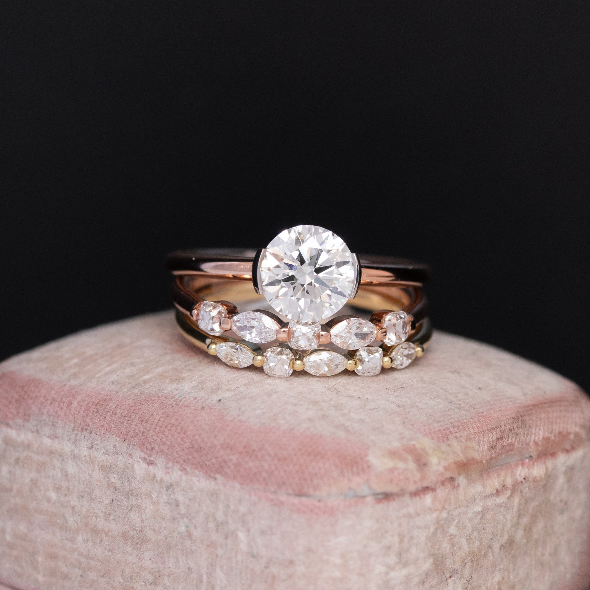 1.21ct round brilliant diamond ring in a half-bezel setting paired with mixed marquise and old mine cut diamond stacking bands
