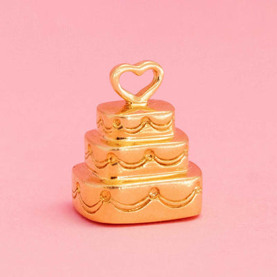Vintage Tiffany & Co. triple tier cake tower charm with heart topper in 18kt yellow gold on pink background