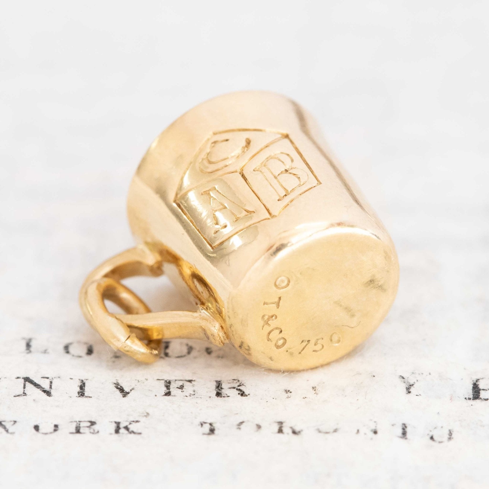 Close-up of Tiffany & Co. baby cup charm in yellow gold, vintage collectible jewelry.
