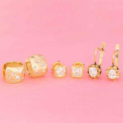 Assorted vintage and antique gold earrings with diamond details, including clip-ons, studs, and dangle styles