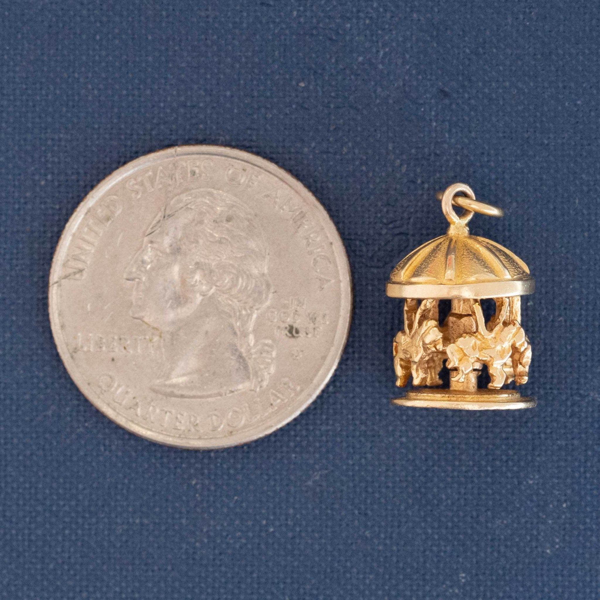 Collector’s gold charm shaped like a carousel with domed top and horses.