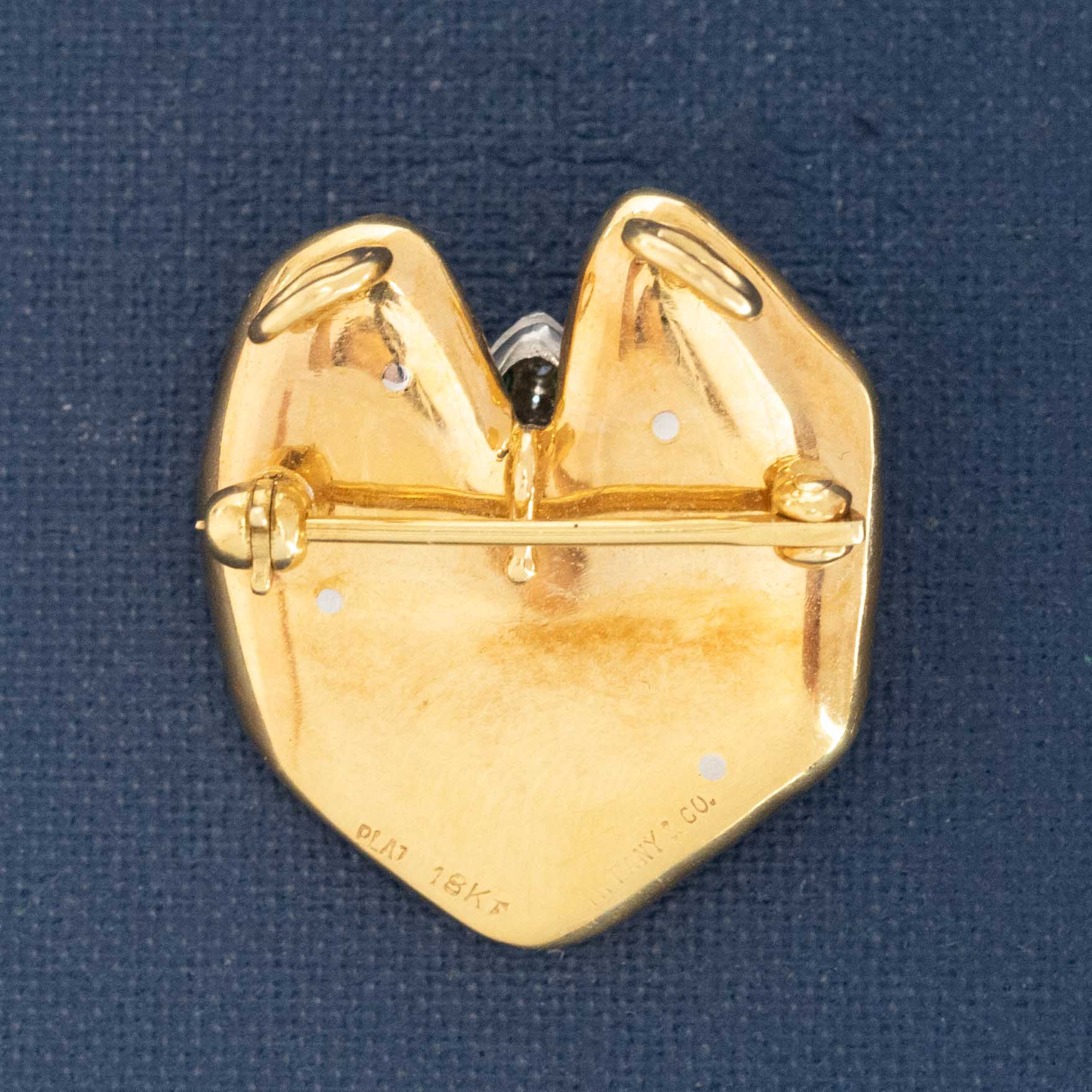 Tiffany-style frog brooch in 18k gold and platinum on blue background