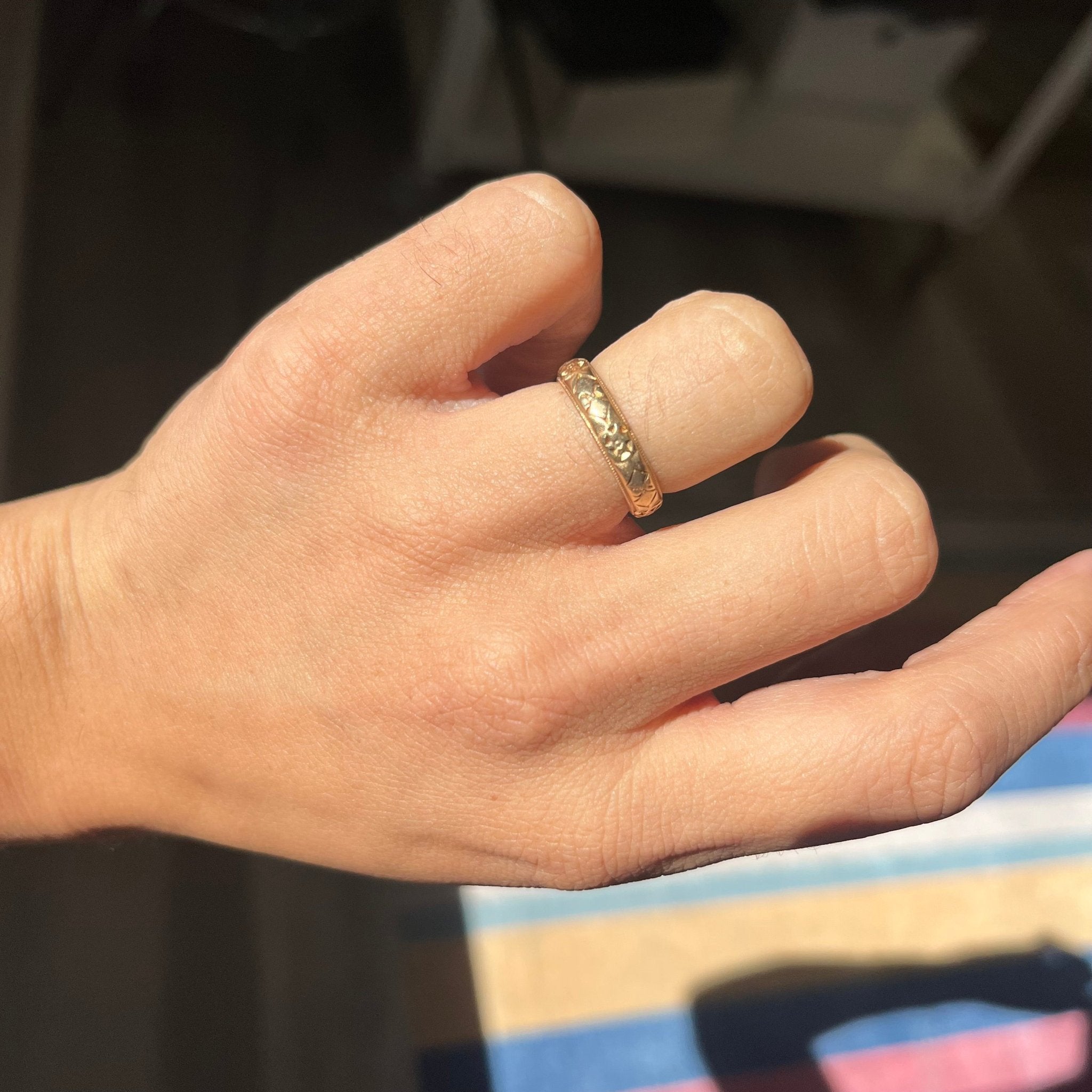 hand shot of romantic and classic 14kt gold band, antique wedding jewelry.