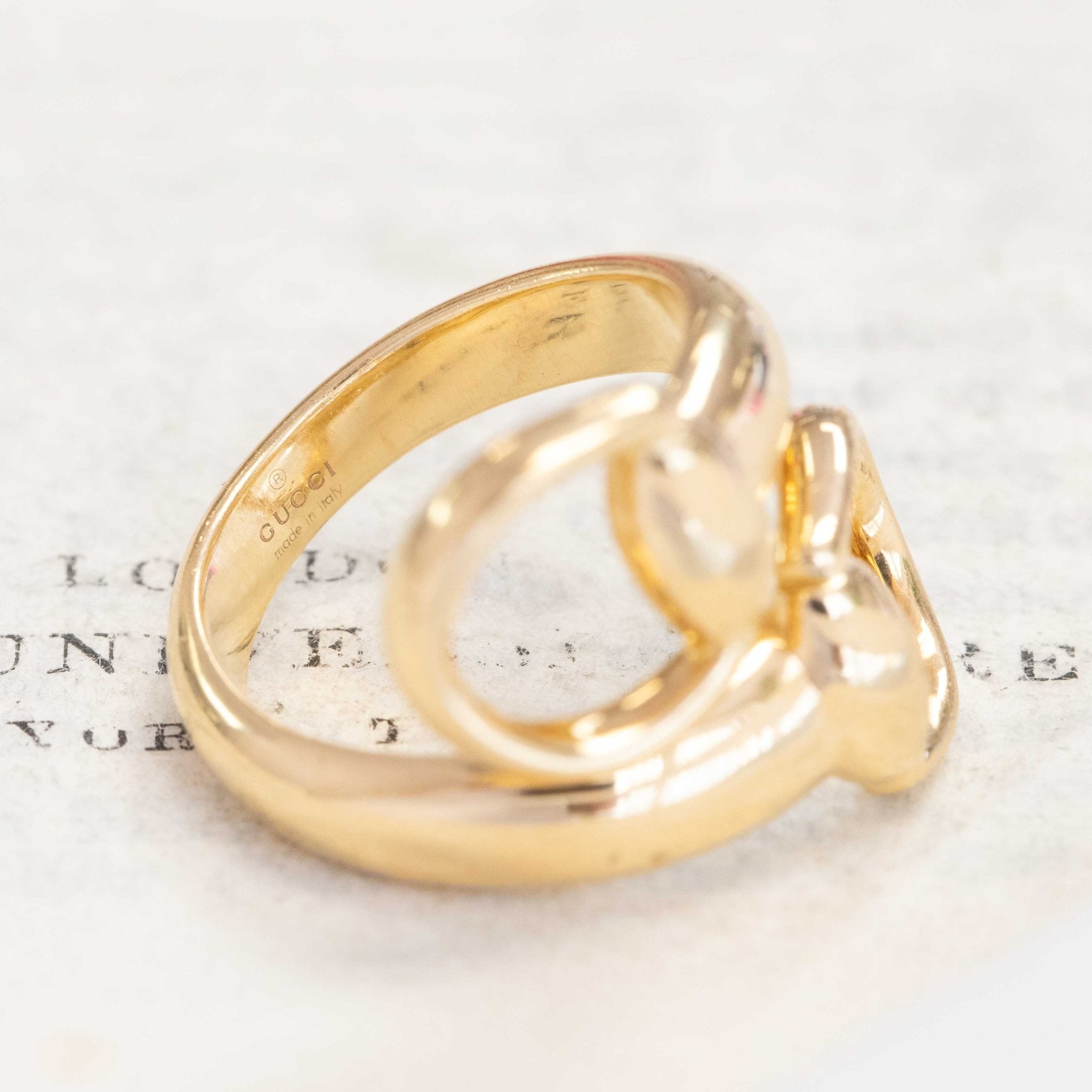 Iconic Gucci horsebit gold ring, wraparound bypass style with equestrian heritage.