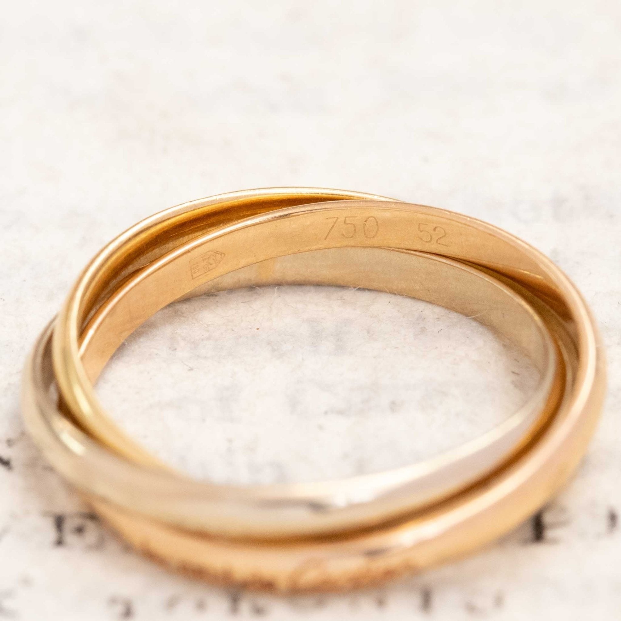 Close-up of Cartier rolling ring, rose-yellow-white gold bands
