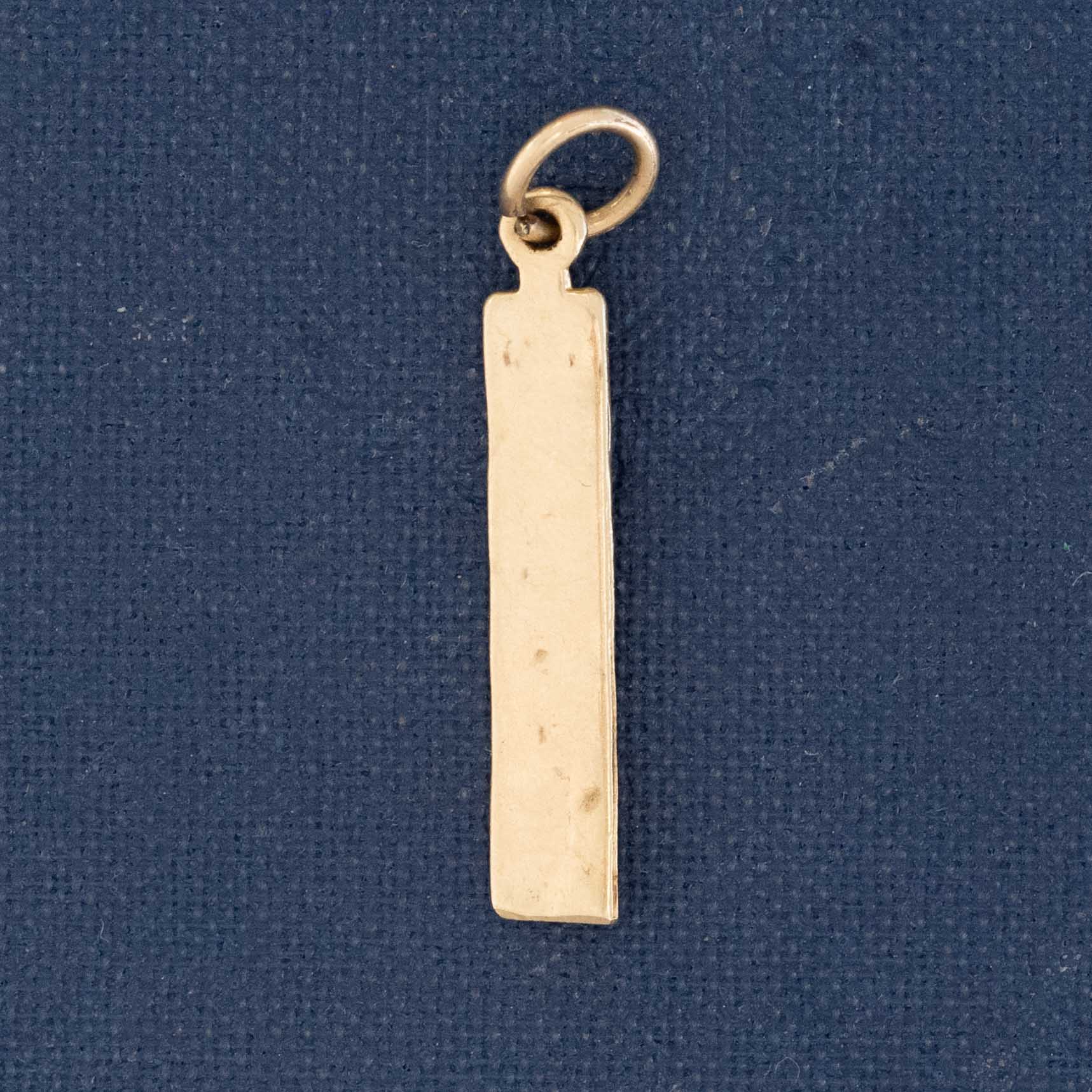 antique gold charm depicting a miniature ruler