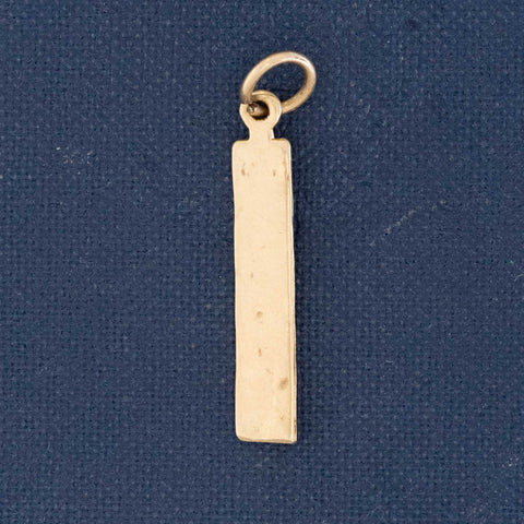 antique gold charm depicting a miniature ruler