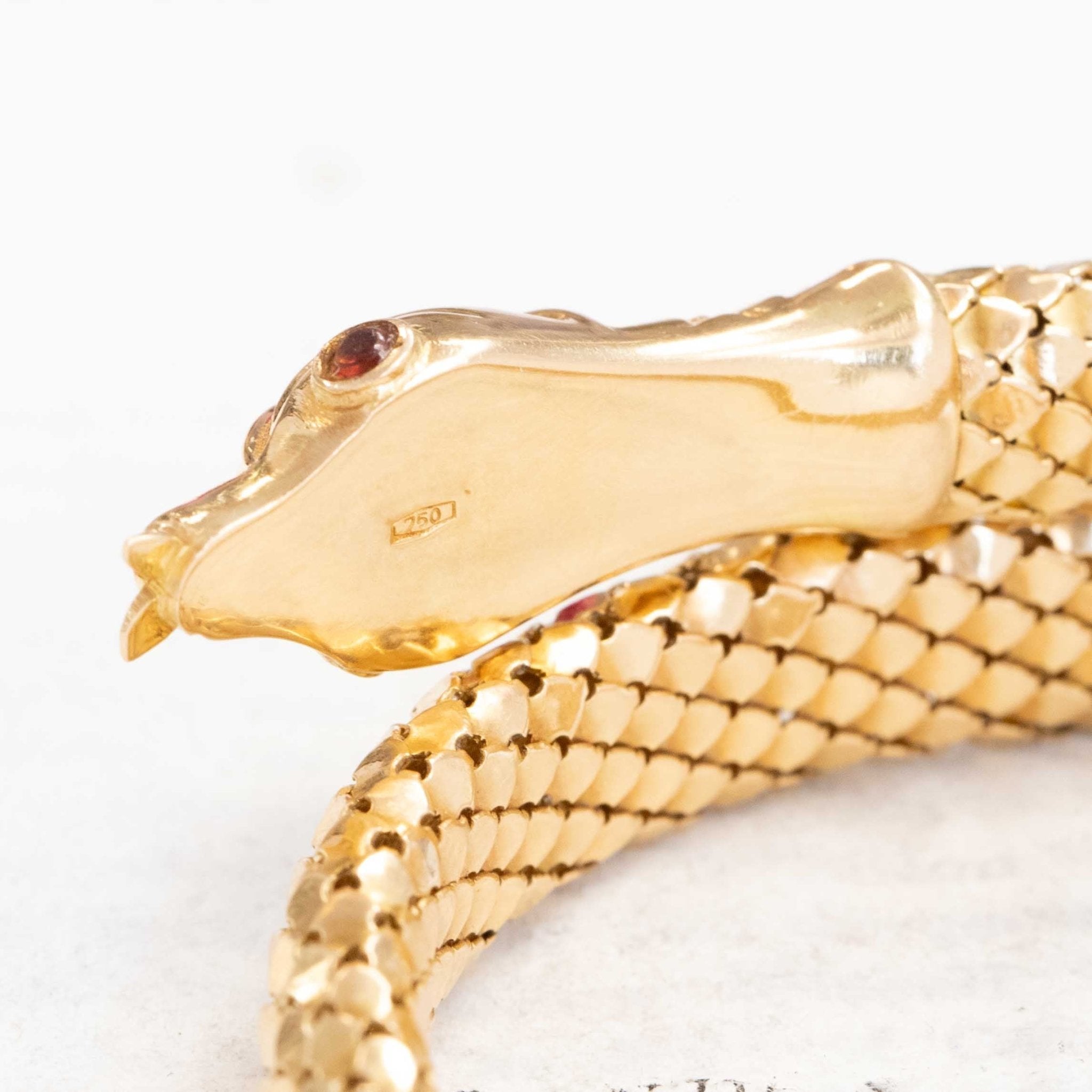 a beautiful vintage serpent themed bracelet with beautiful, realistic texture in rich yellow gold and ruby eyes.
