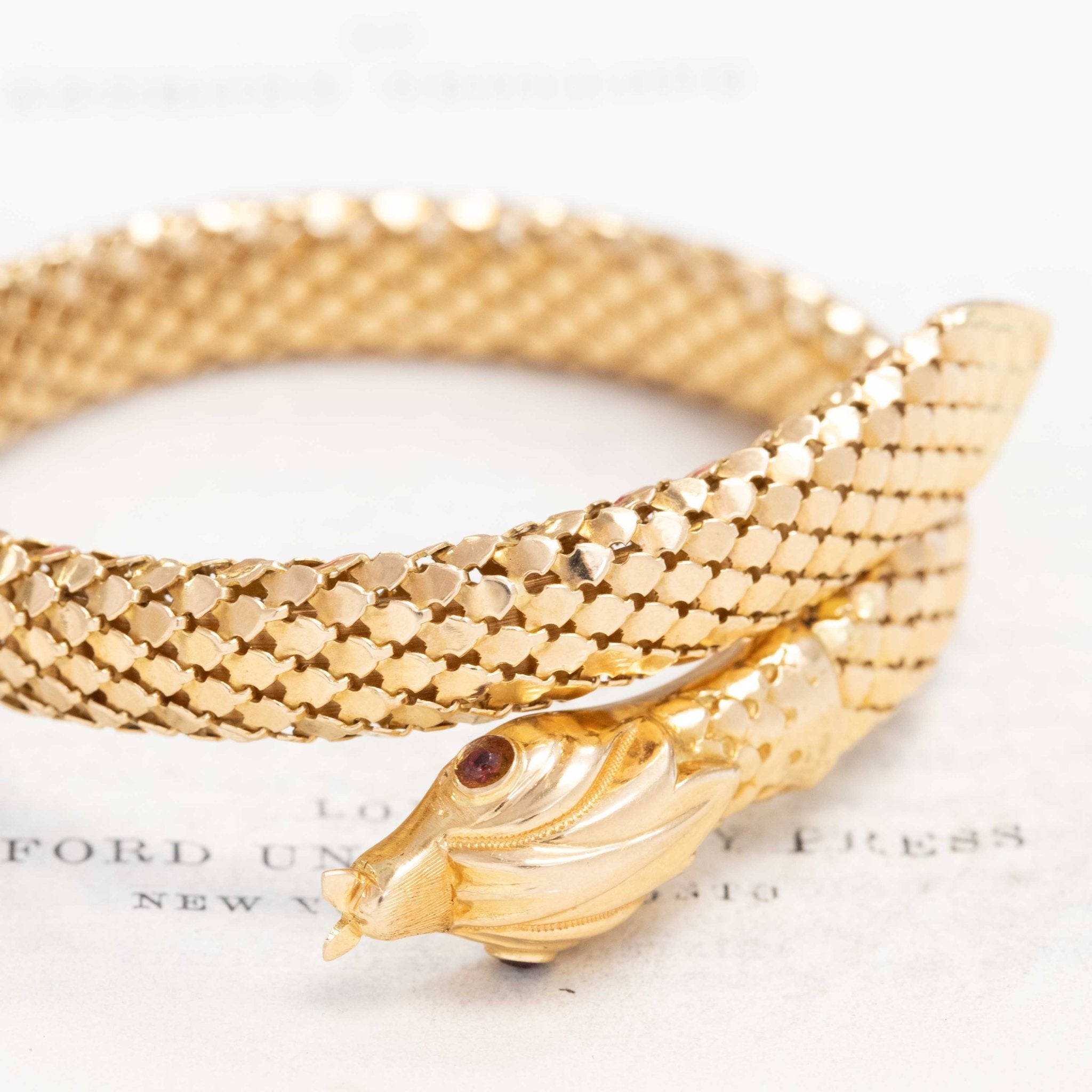 a beautiful vintage serpent themed bracelet with beautiful, realistic texture in rich yellow gold and ruby eyes.