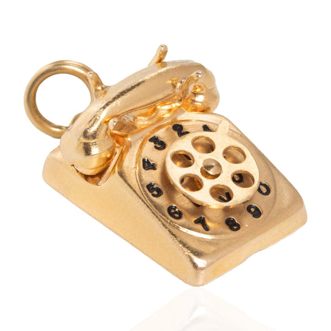 A gold vintage rotary telephone charm pendant with a hanging loop, shown on a clean white background.