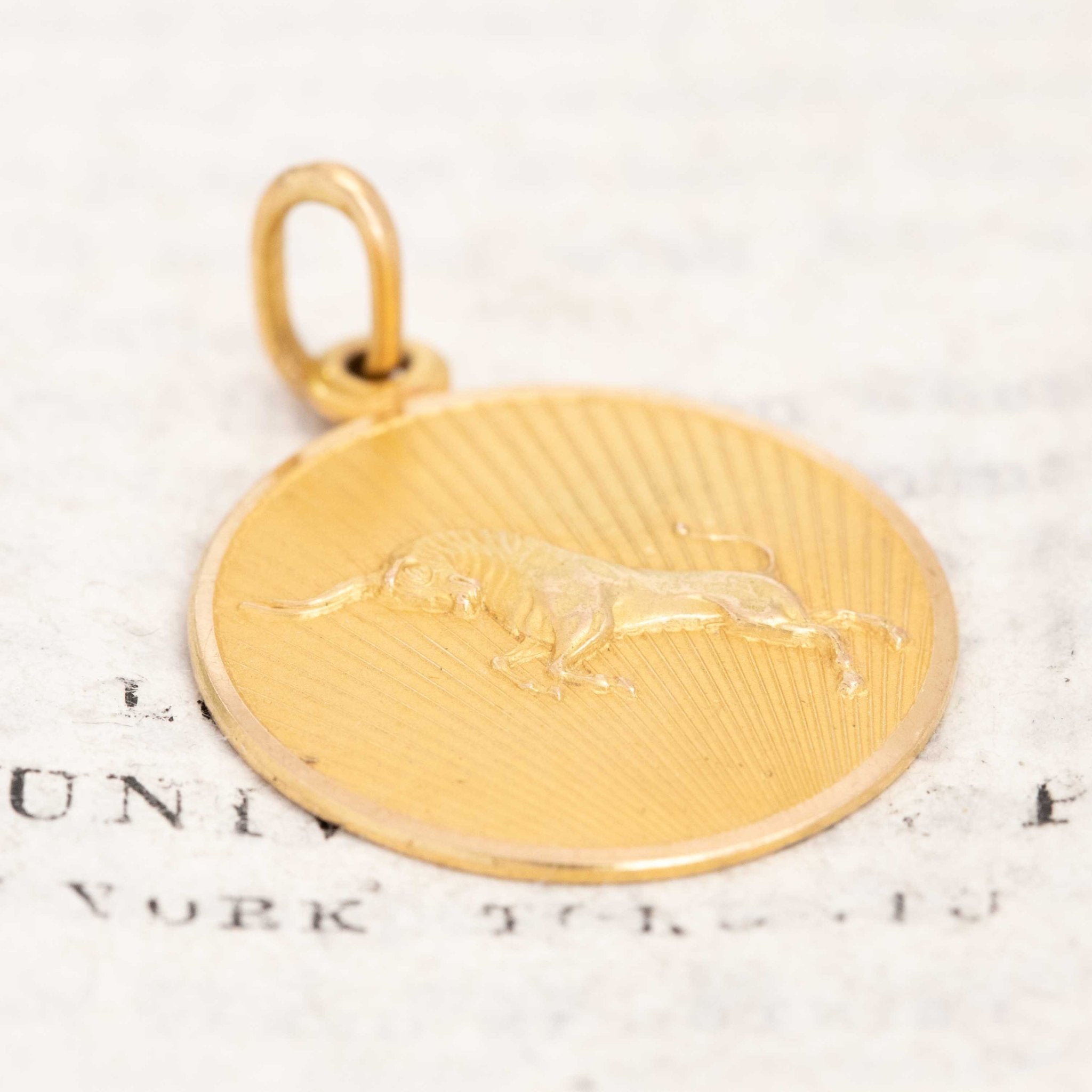 Astrology-themed vintage gold charm for Taurus sign. Round zodiac medallion featuring bull engraving