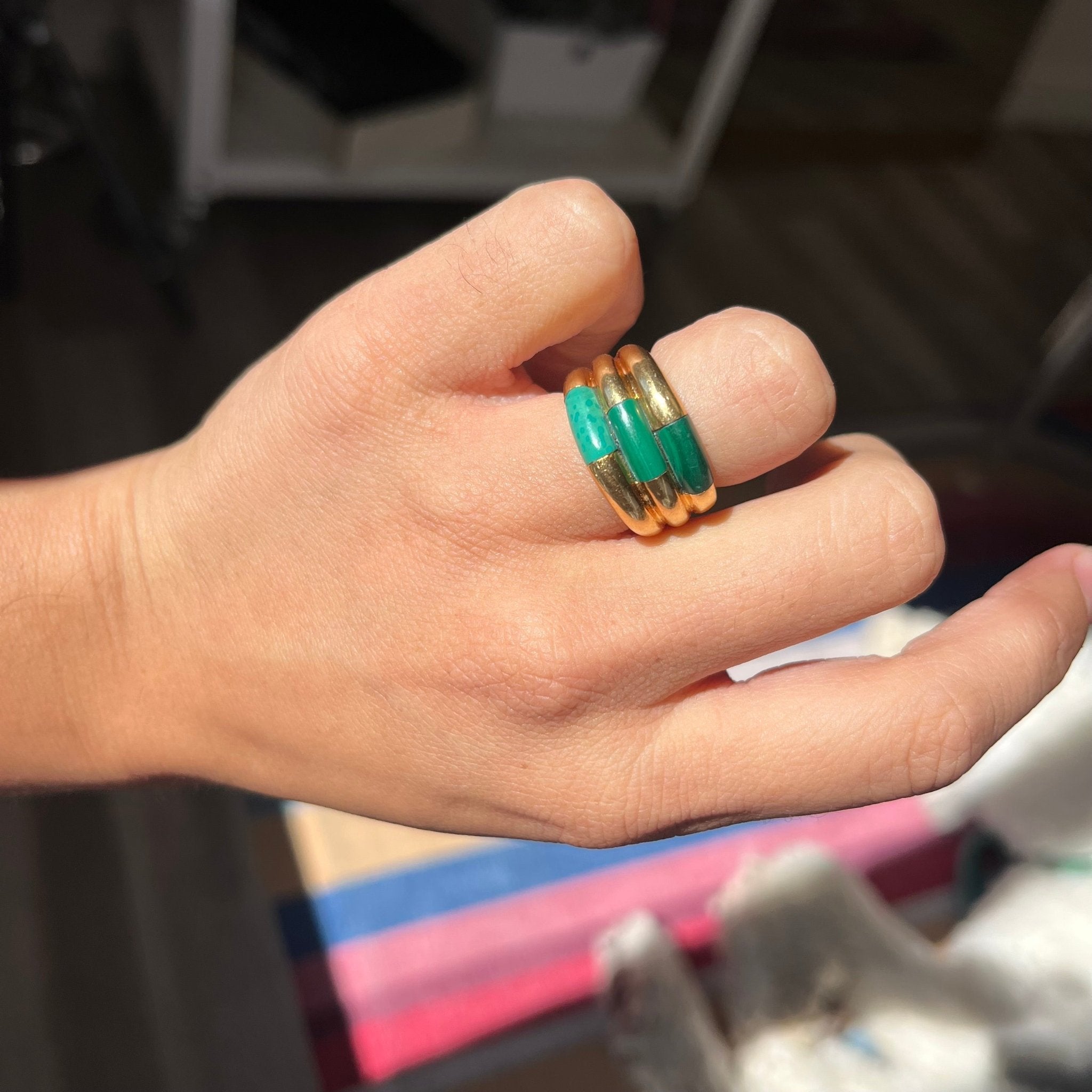 Hand shot of a Retro gold band featuring natural malachite cabochon design