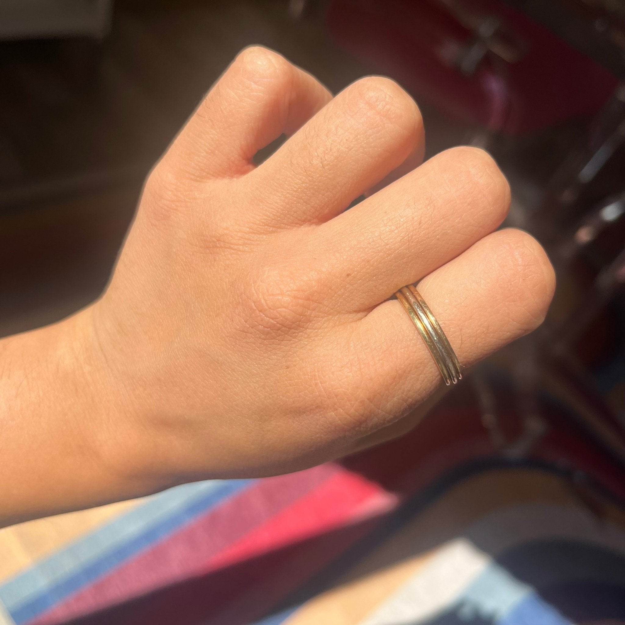 Close-up Cartier triple row band on hand