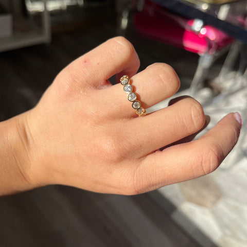 Elegant .90ctw Old European Cut Diamond Bezel 7-Stone Band, romantic design with Old European Cut Diamonds, Earth-mined diamonds in yellow gold shown on ring finger