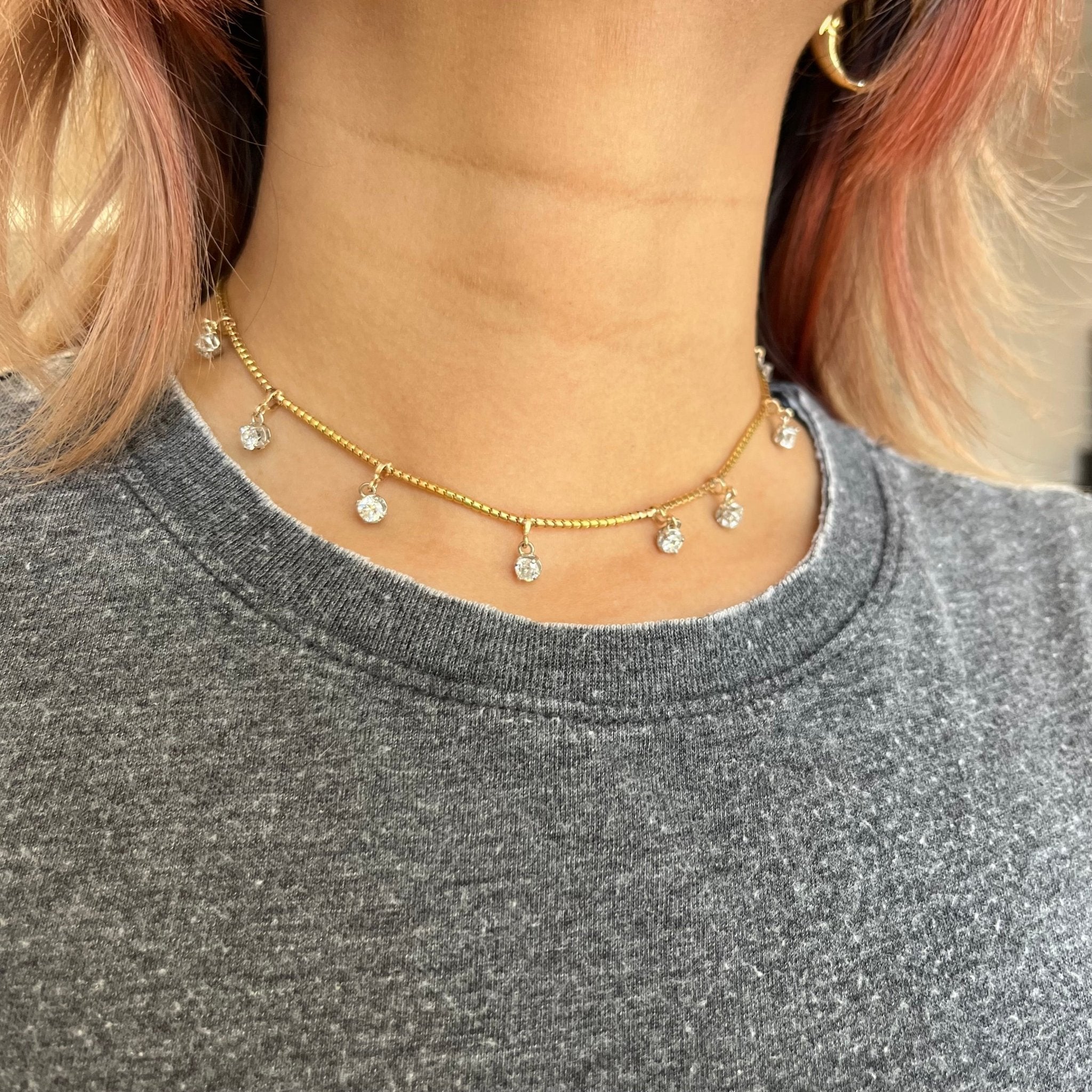 Close-up of vintage diamond choker necklace in yellow gold with slinky chain and OEC diamonds.
