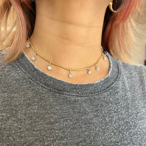 Close-up of vintage diamond choker necklace in yellow gold with slinky chain and OEC diamonds.