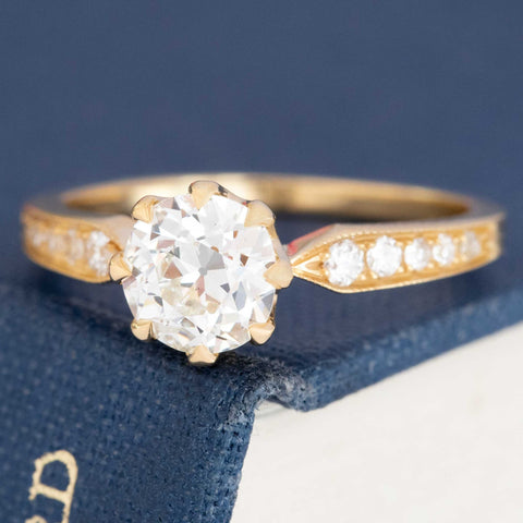 Classic diamond engagement ring with OEC center and side stones, vintage 18k gold setting.