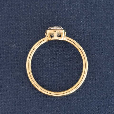 Side view of bezel-set old mine cut diamond solitaire yellow gold band
